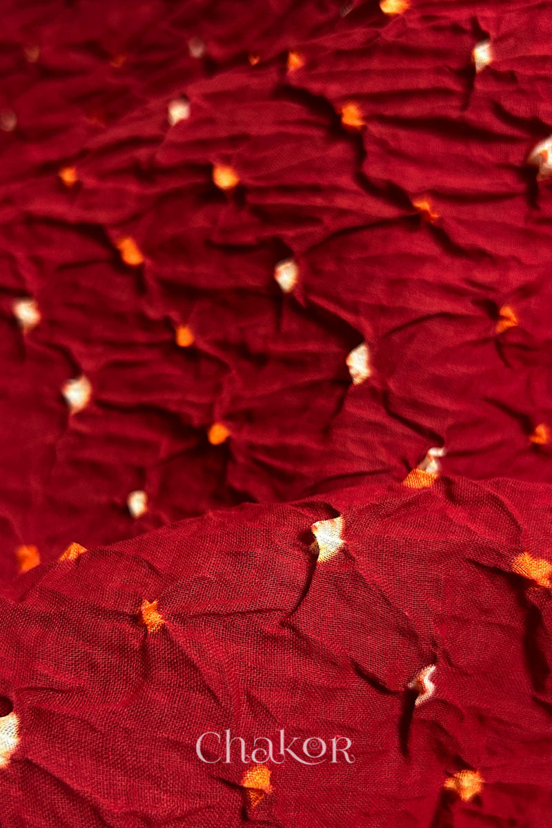 Close up of Red body and Black Bandhani Mul Cotton Saree featuring multicouloured bandhani patterns.