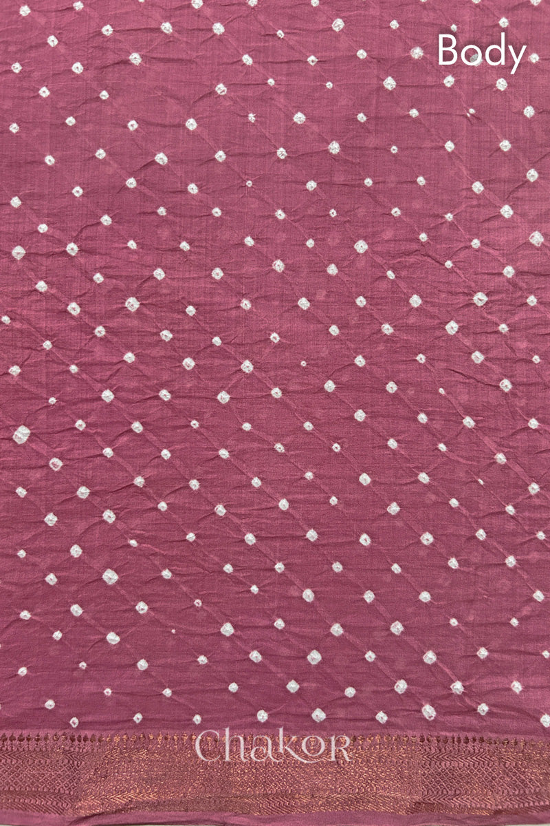 Body detail of Old rose bandhani saree with woven golden zari border.
