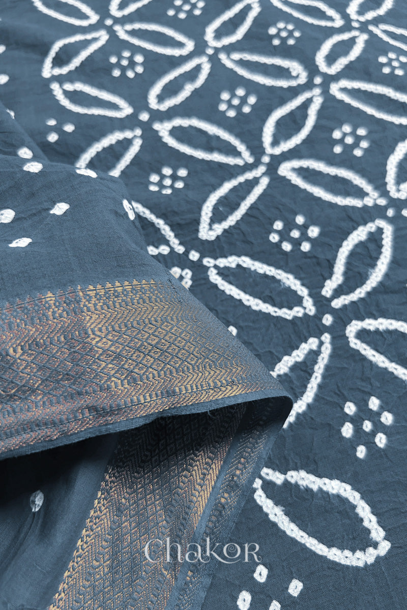 Close-up of grey sarees featuring rai bandhani and zari weaving showcasing beautiful craftsmanship.
