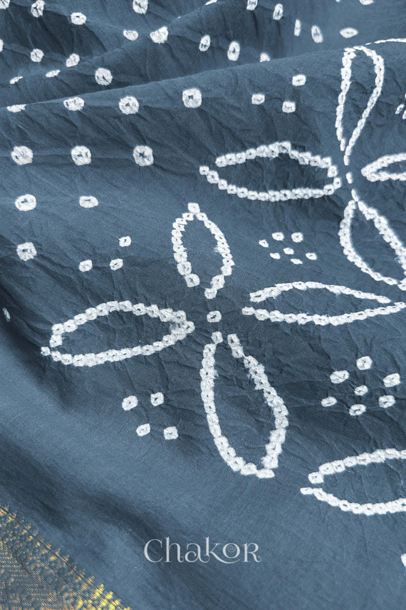 Close-up of grey sarees featuring rai bandhani and zari weaving showcasing beautiful craftsmanship.
