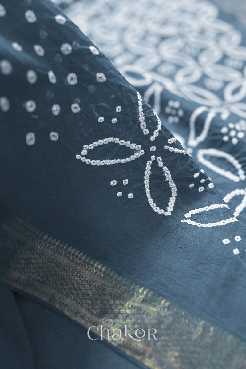 Close-up of grey sarees featuring rai bandhani and zari weaving showcasing beautiful craftsmanship.
