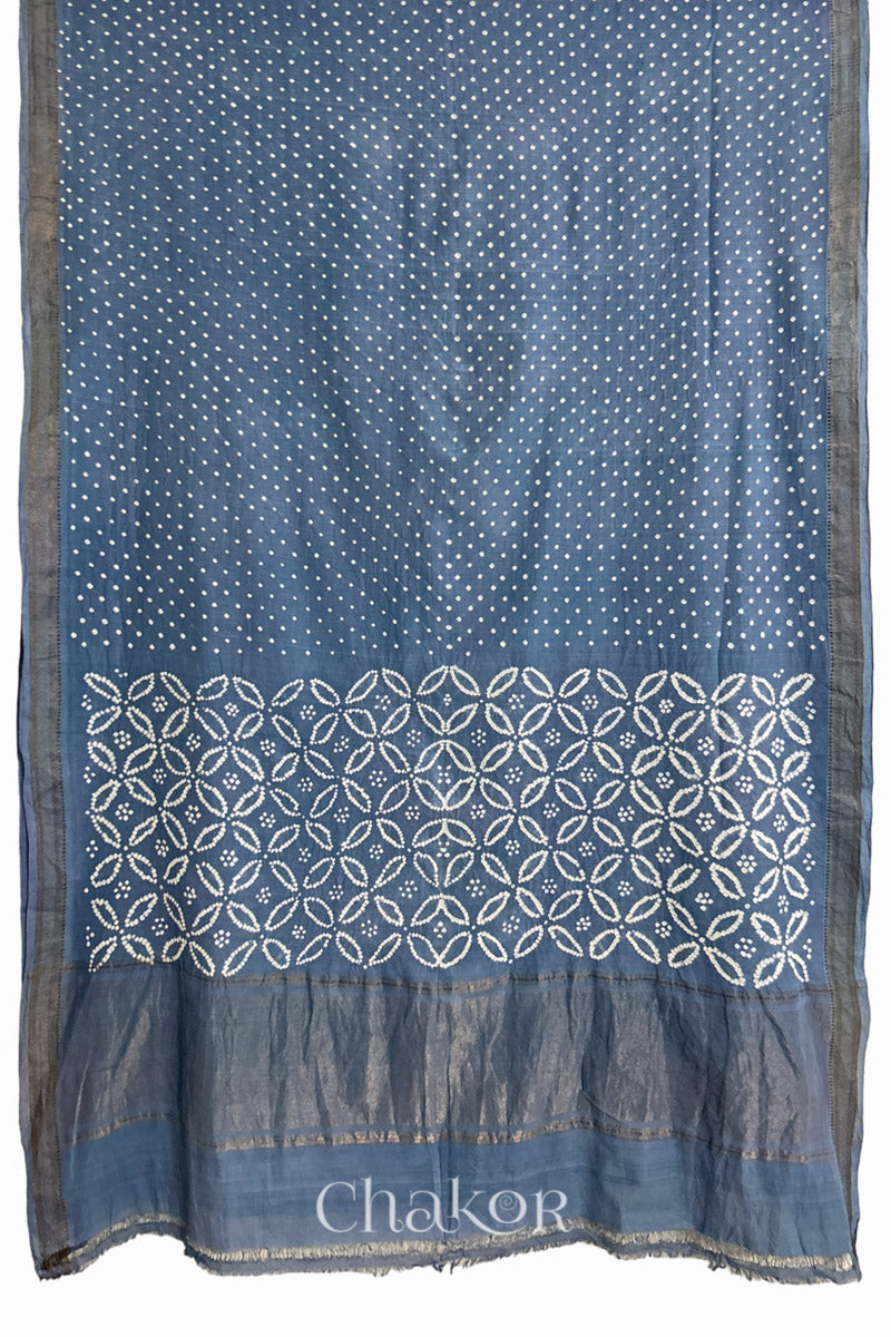 grey saree, flat draped with Rai Bandhej traditional design against white background and 'Chakor' watermark.

