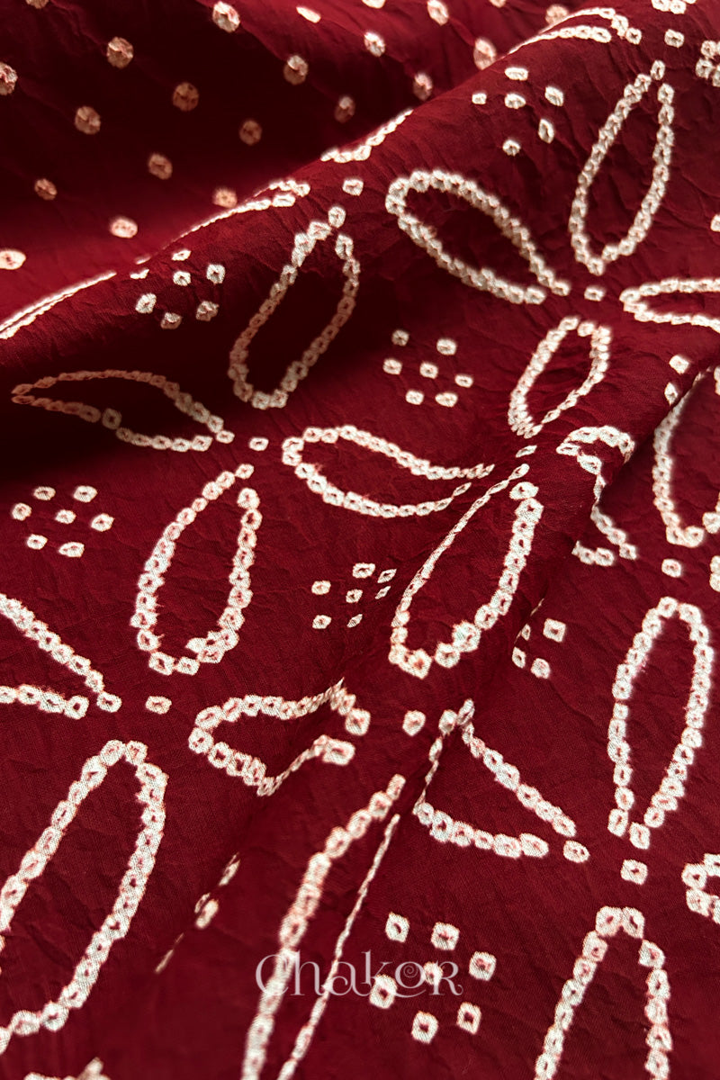 Close-up of Red sarees featuring rai bandhani showcasing beautiful craftsmanship.
