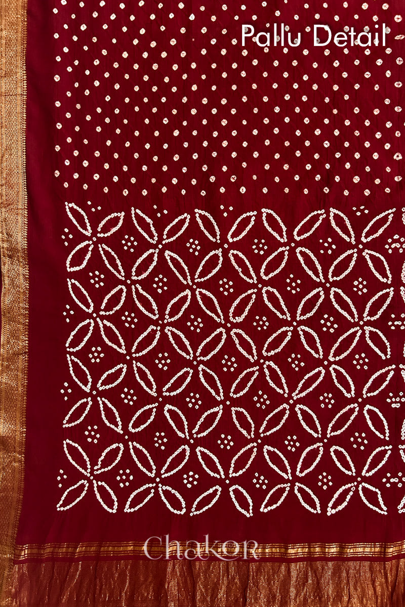 Pallu detail of Red bandhani saree with woven golden zari border and pallu.
