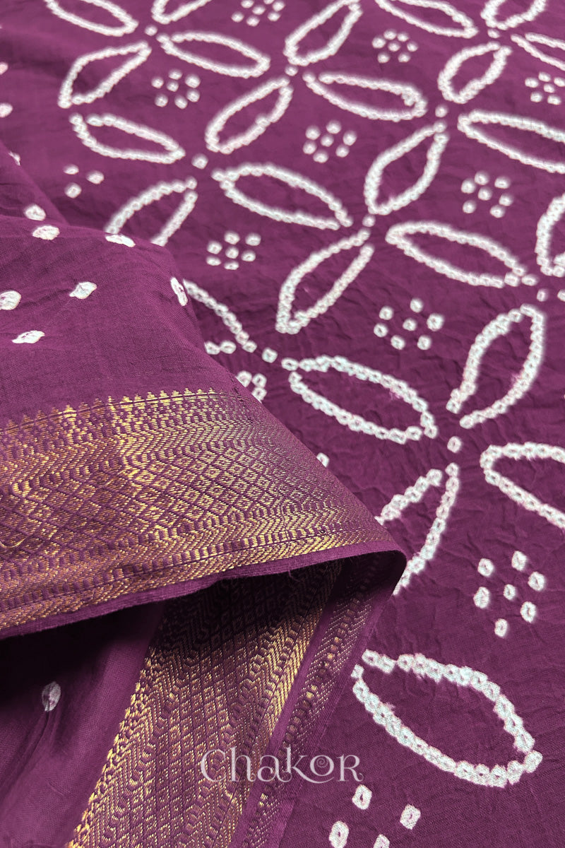 Close-up of Purple sarees featuring rai bandhani and zari weaving showcasing beautiful craftsmanship.
