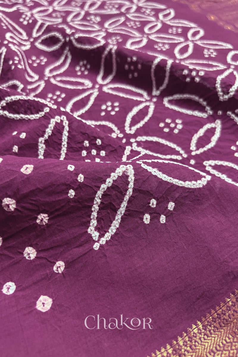 Close-up of Purple sarees featuring rai bandhani and zari weaving showcasing beautiful craftsmanship.
