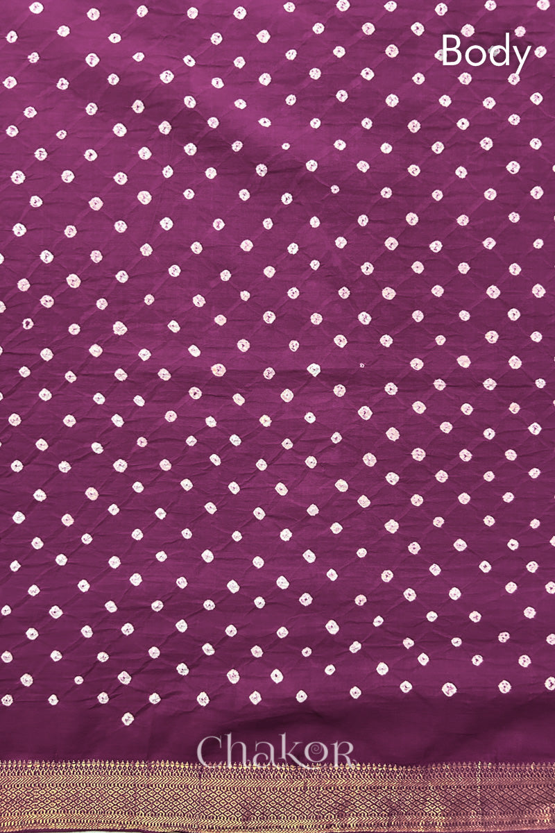 Body detail of Purple bandhani saree with woven golden zari border.
