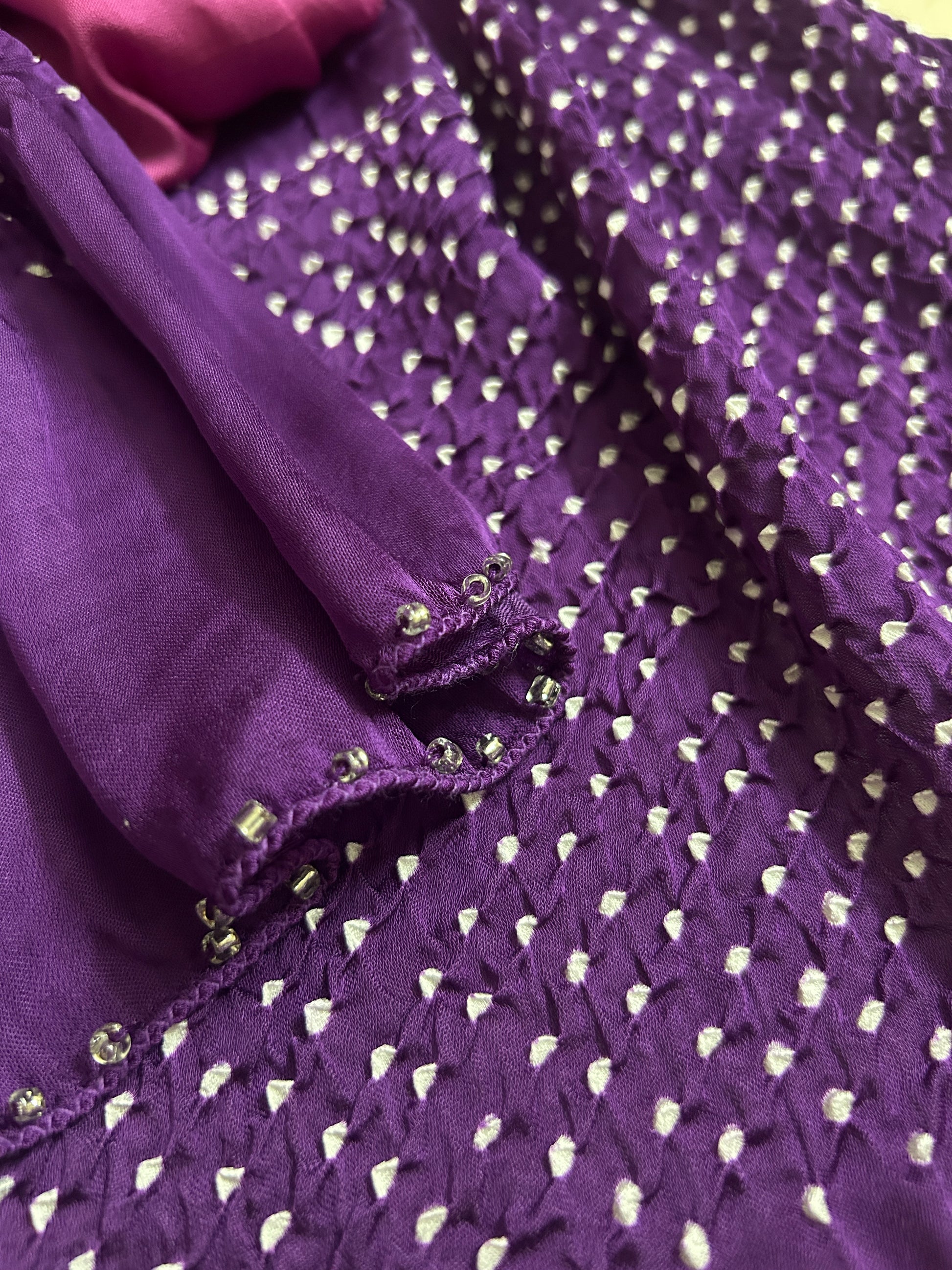 Close-up of bandhani stole featuring ombre dyeing & intricate tie dye and beads edging with 'Chakor' branding.

