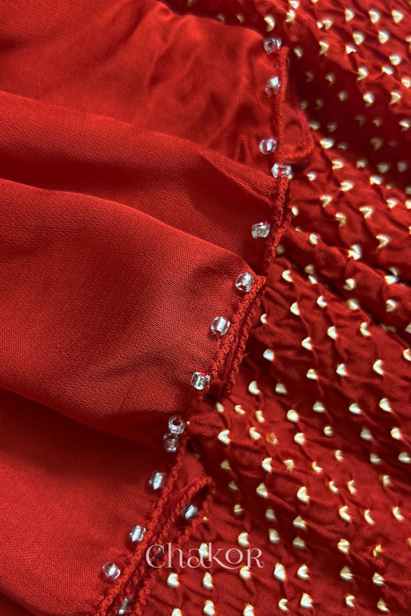 Close-up of bandhani stole featuring ombre dyeing & intricate tie dye and beads edging with 'Chakor' branding.
