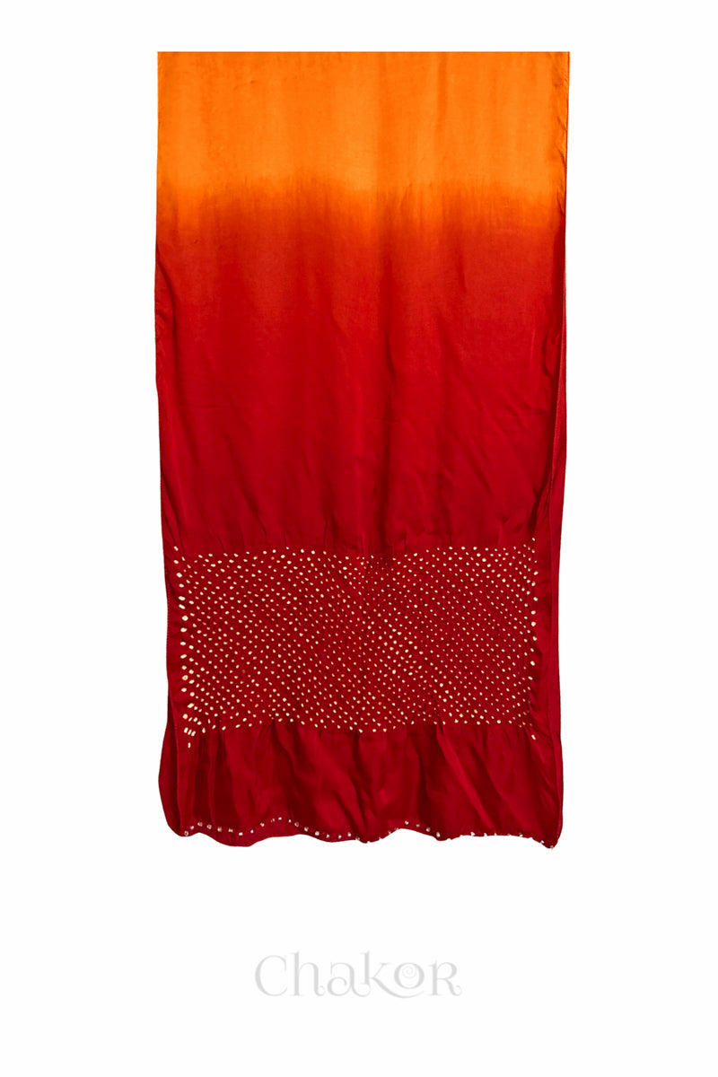Full view of bandhani stole featuring ombre dyeing in orange & red and lustrous texture of modal fabric with 'Chakor' branding.
