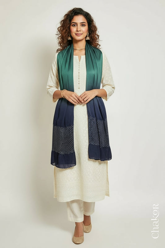 Woman wearing a teal & mauve shaded bandhani stole on white kurta set.

