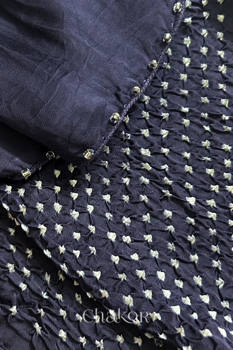Close-up of bandhani stole featuring ombre dyeing & intricate tie dye and beads edging with 'Chakor' branding.
