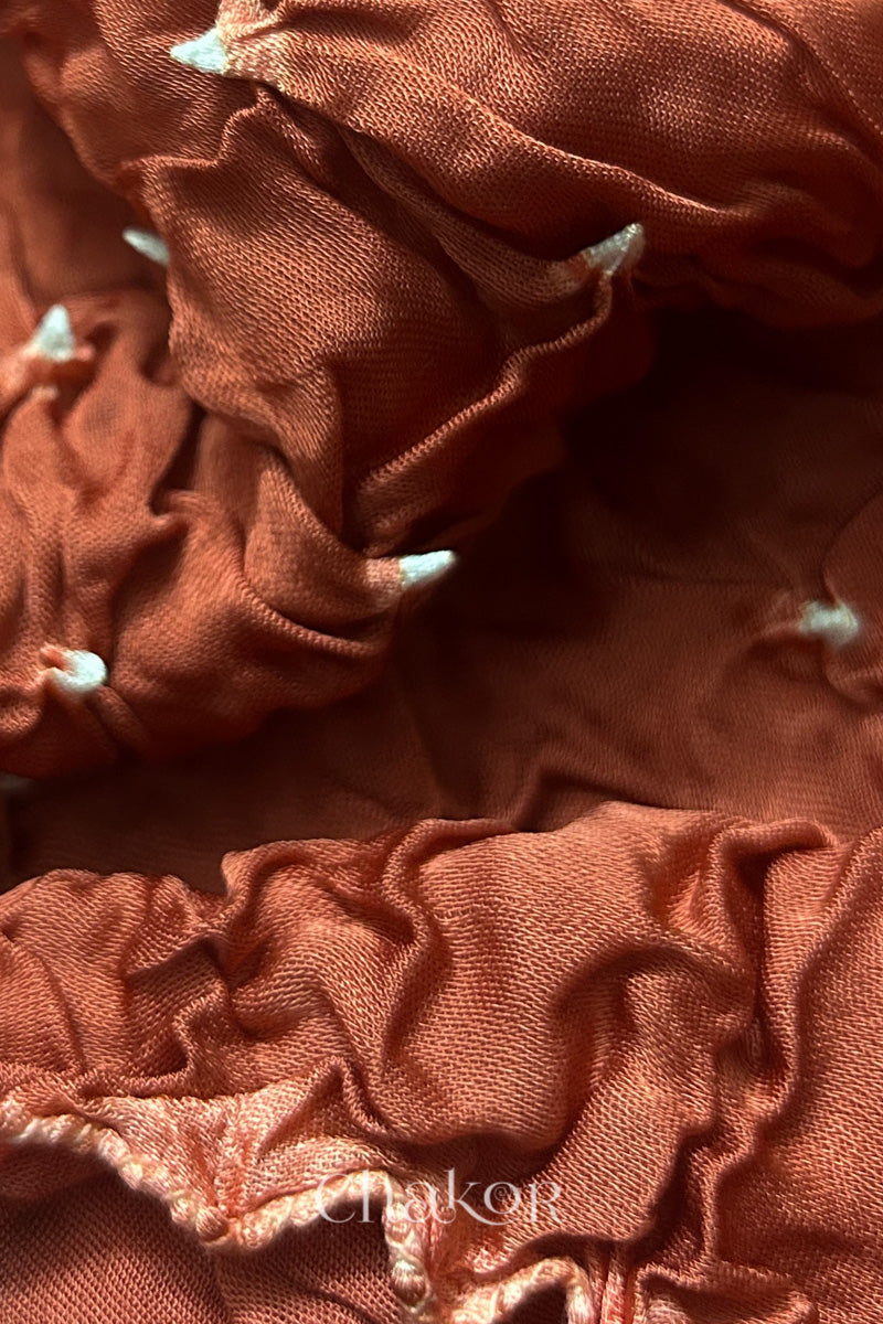 Close-up of coral Bandhani modal fabric showing hand tie-dye Chakri motifs.