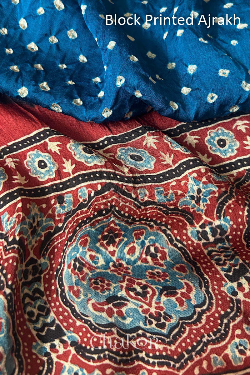 Close up of natural dye red Ajrakh print on handcrafted stole with intricate block printed motifs and delicate bandhani patterns.
