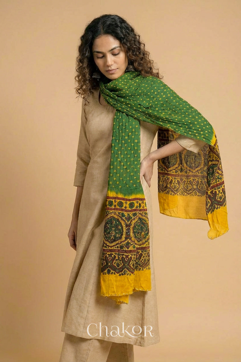 Green Bandhani modal stole styled across shoulders with detailed Mustard Ajrakh pallu and traditional hand tied pattern.

