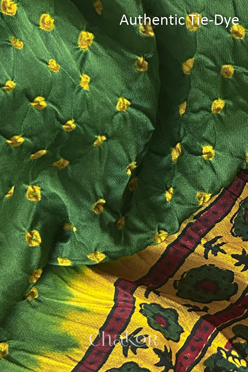 Green Hand tied Bandhani dots on modal stole with contrast ajrakh pallu detail showcasing fabric texture and softness.
