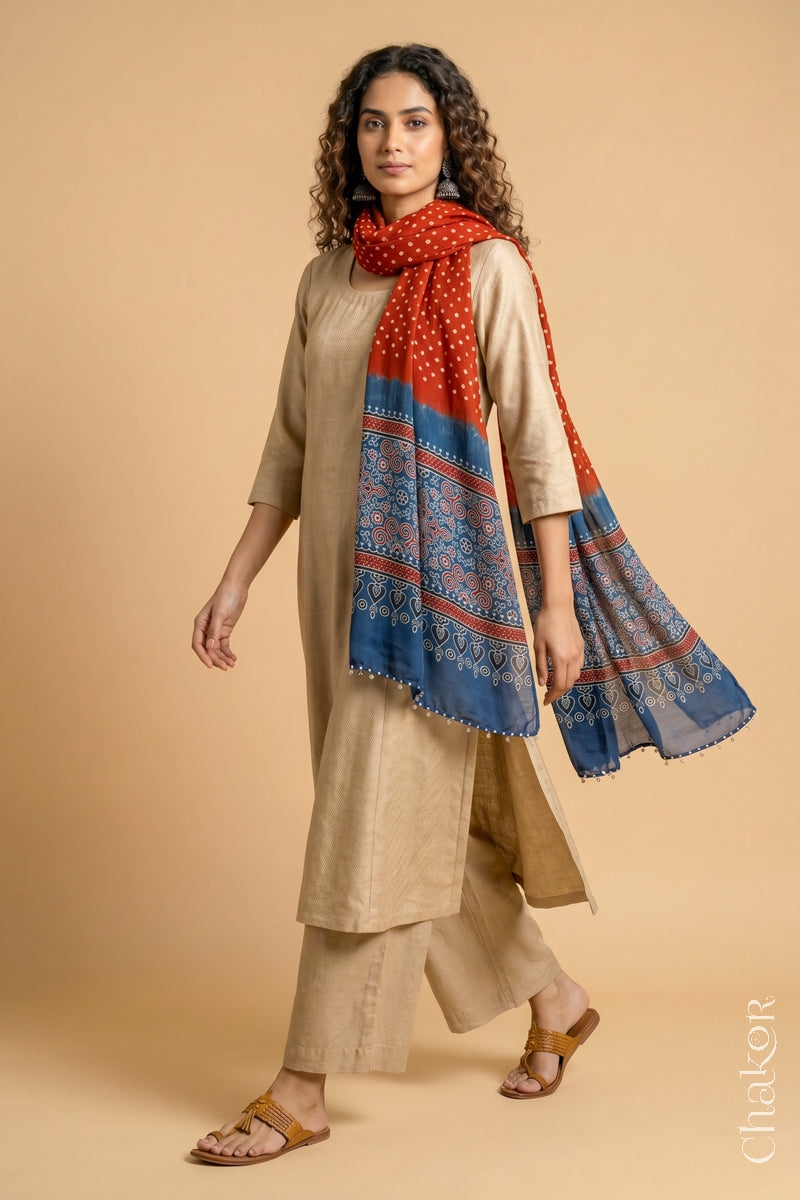  Red Bandhani modal stole styled across shoulders with detailed Indigo Ajrakh pallu and traditional hand tied pattern.
