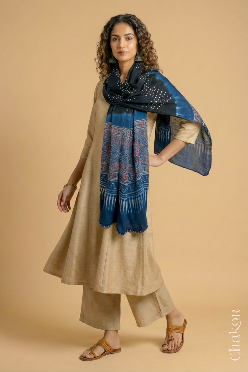 Black Bandhani modal stole styled across shoulders with detailed Indigo Ajrakh pallu and traditional hand tied pattern.
