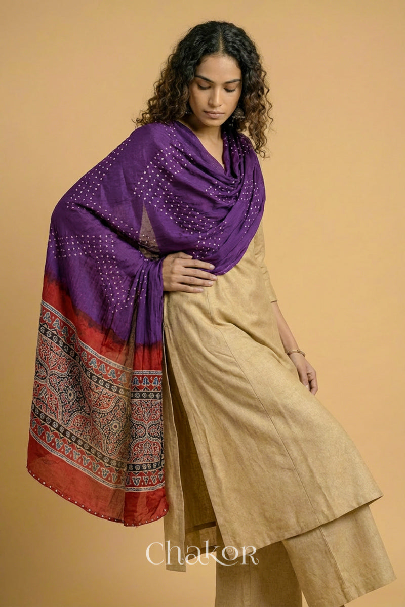 Purple Bandhani modal stole styled across shoulders with detailed Madder Red Ajrakh pallu and traditional hand tied pattern.
