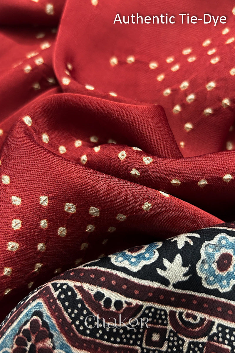 Red Hand tied Bandhani dots on modal stole with contrast ajrakh pallu detail showcasing fabric texture and softness.
