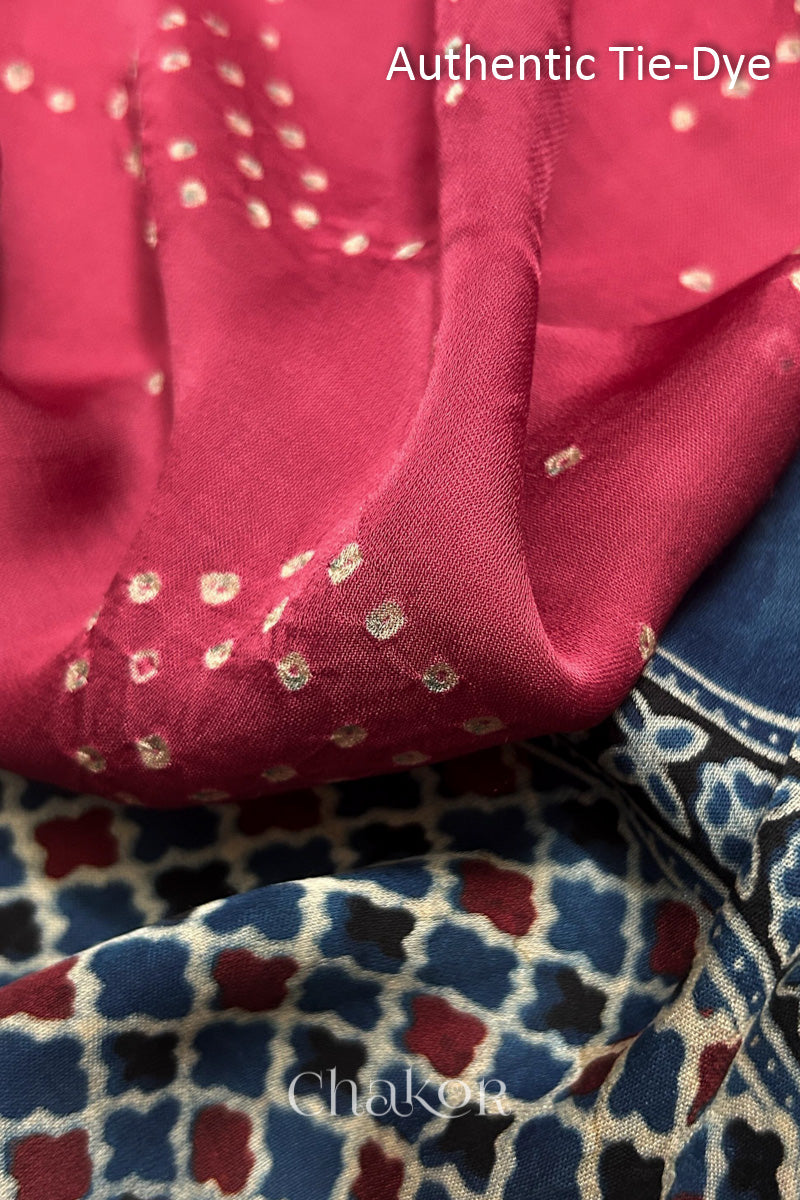 Strawberry Pink Hand tied Bandhani dots on modal stole with contrast ajrakh pallu detail showcasing fabric texture and softness.
