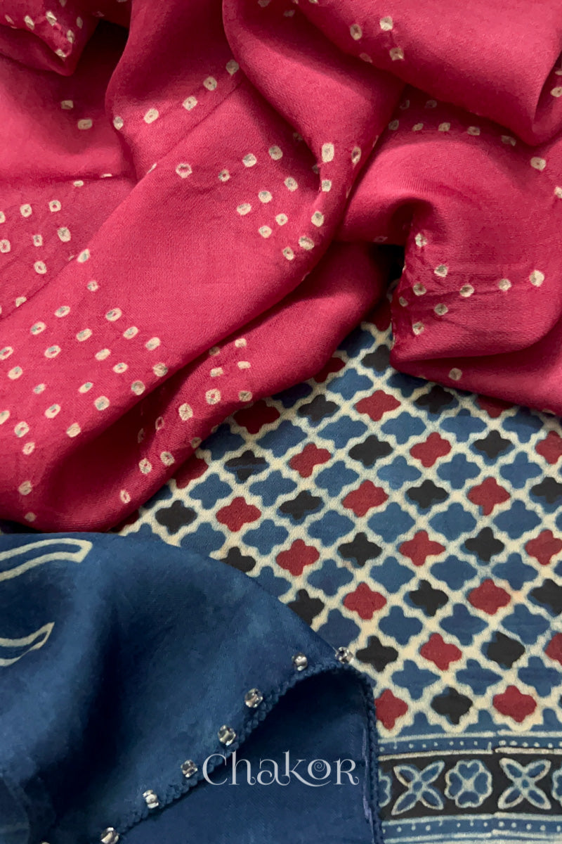 Strawberry Pink Hand tied Bandhani dots on modal stole with contrast indigo ajrakh pallu detail showcasing fabric texture and softness & glass bead edging.