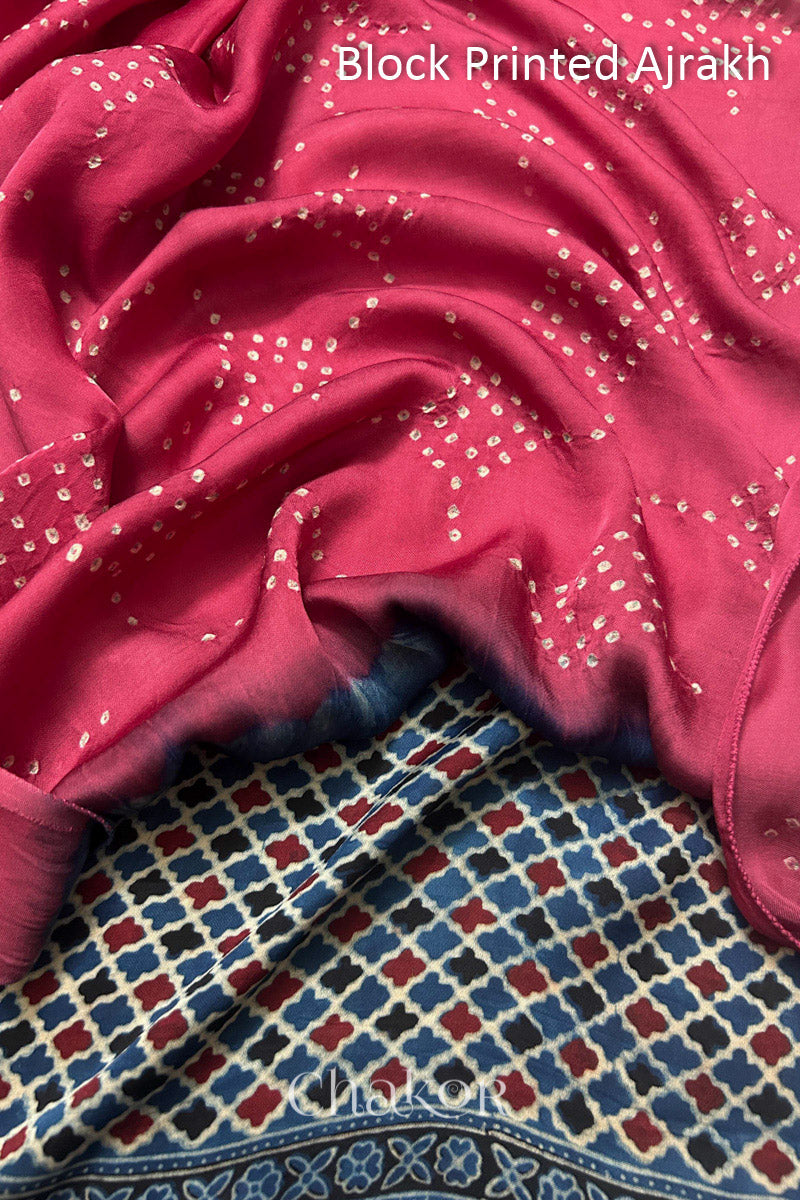 Close up of natural dye Indigo Ajrakh print on handcrafted stole with intricate block printed motifs and delicate bandhani patterns on strawberry pink.
