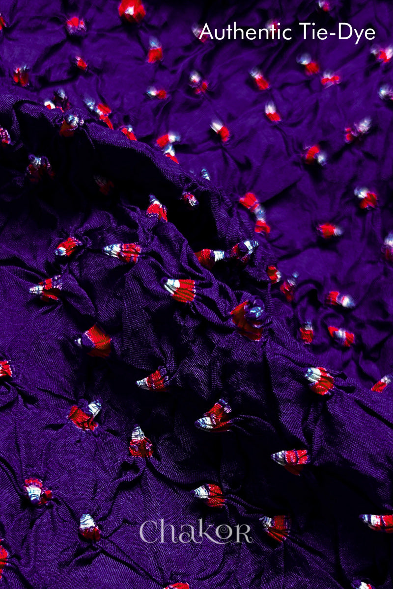 Close-up of Purple mulberry silk fabric with Red and white patterns, featuring texture of authentic bandhani patterns.
