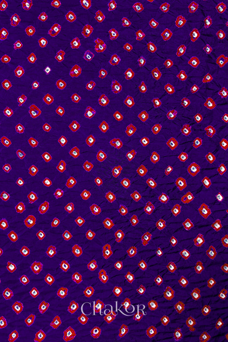 Purple Mulberry silk fabric showcasing dual colour Red bandhani patterns and Chakor brand watermark.

