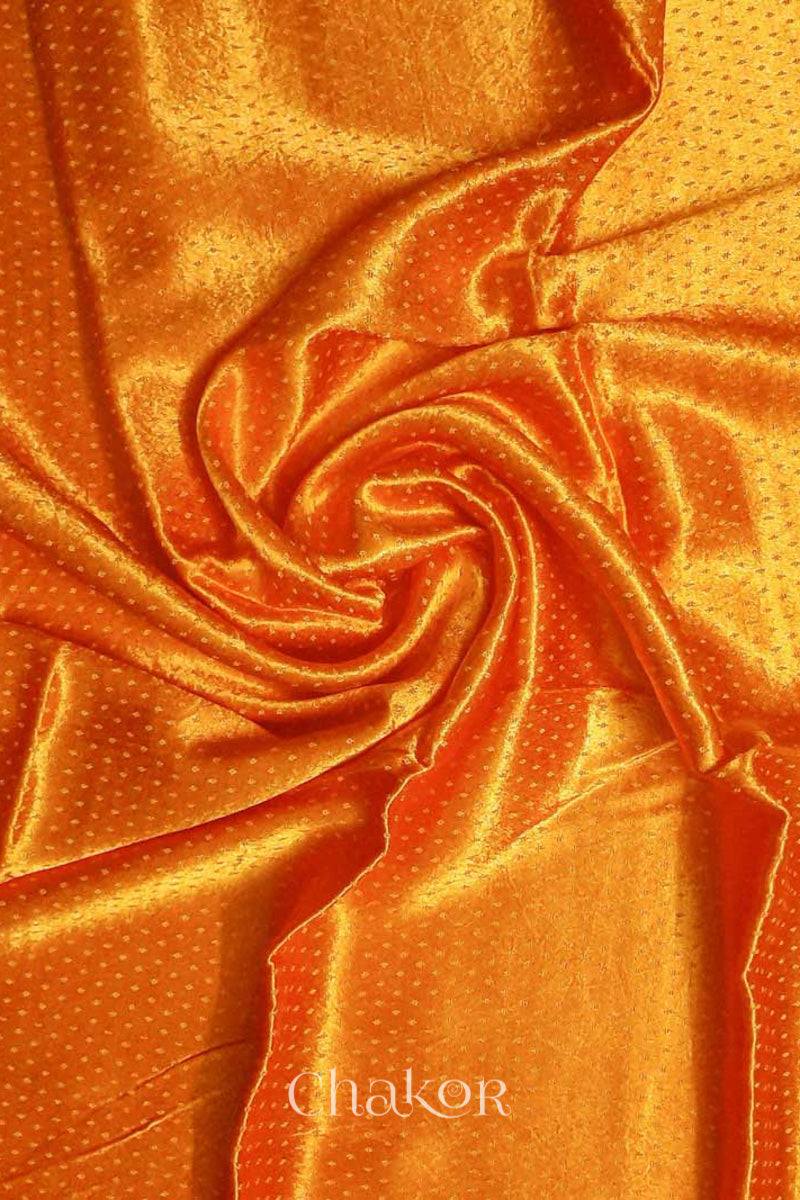 Close up of Handcrafted Haldi Yellow Mashru Blouse Fabric with self woven design and silky texture.