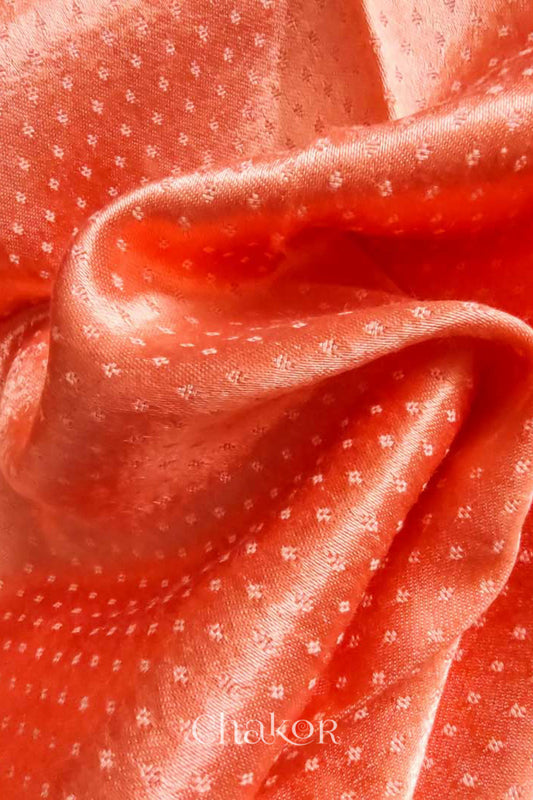 Close up of Handcrafted Peach Mashru Blouse Fabric with self woven design and silky texture.