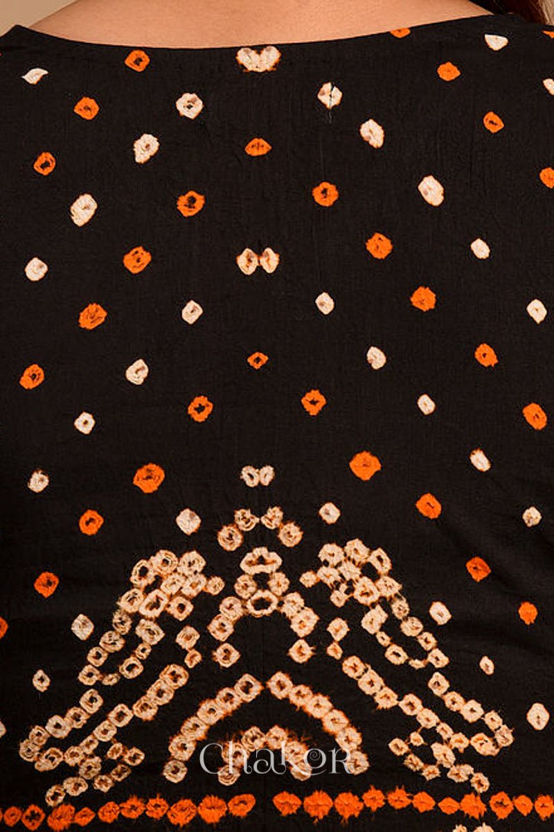 Woman wearing a handcrafted purple bandhani cotton blouse with intricate parrot motifs and boria buttons on front.
