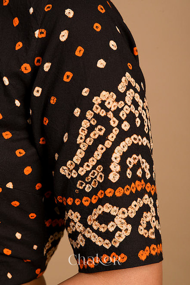 Woman wearing a handcrafted purple bandhani cotton blouse with intricate parrot motifs and boria buttons on front.