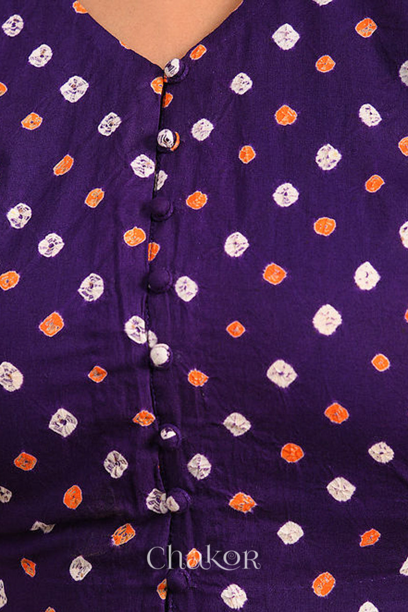 Woman wearing a handcrafted purple bandhani cotton blouse with intricate parrot motifs and boria buttons on front.