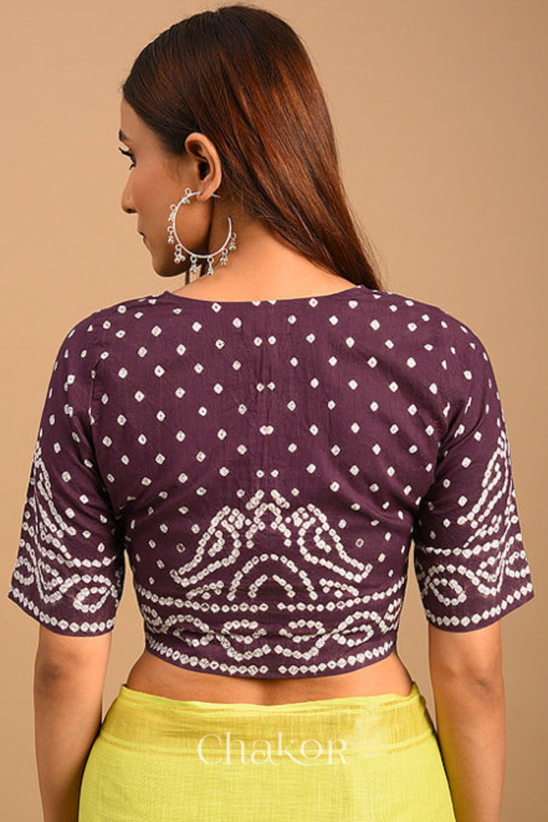 Woman wearing a handcrafted brown bandhani cotton blouse with intricate parrot motifs and boria buttons on front.