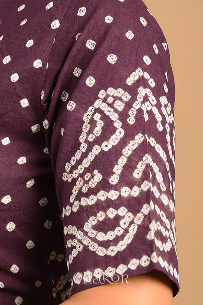Woman wearing a handcrafted brown bandhani cotton blouse with intricate parrot motifs and boria buttons on front.
