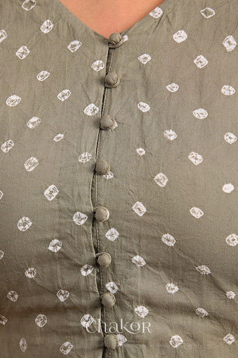 Woman wearing a handcrafted grey bandhani cotton blouse with intricate parrot motifs and boria buttons on front.