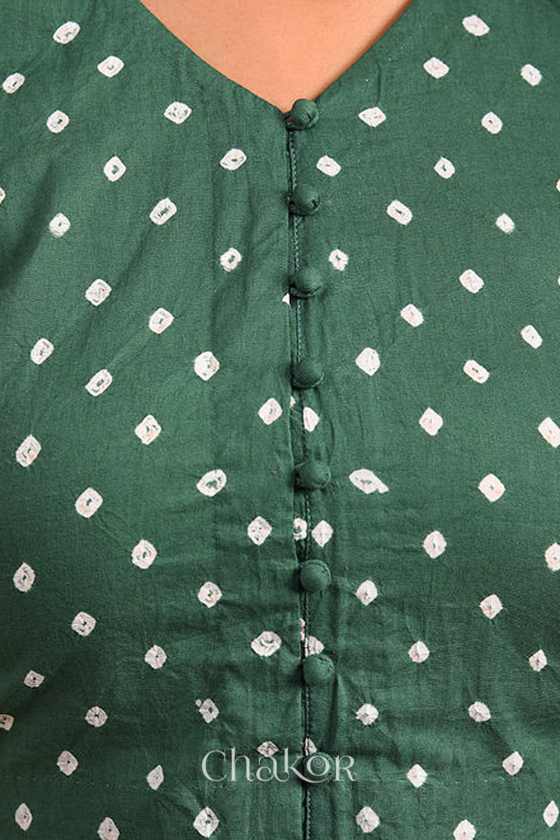 Woman wearing a handcrafted moss green bandhani cotton blouse with intricate parrot motifs and boria buttons on front.