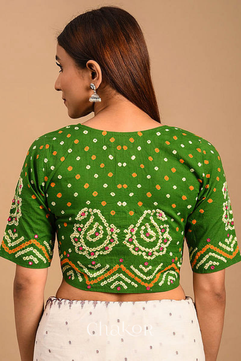 A woman wearing a traditional Mehendi Green Bandhani Cotton Blouse with intricate mirror embroidered Keri - Paisley motifs and boria fabric buttons.