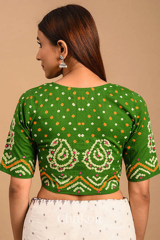 A woman wearing a traditional Mehendi Green Bandhani Cotton Blouse with intricate mirror embroidered Keri - Paisley motifs and boria fabric buttons.