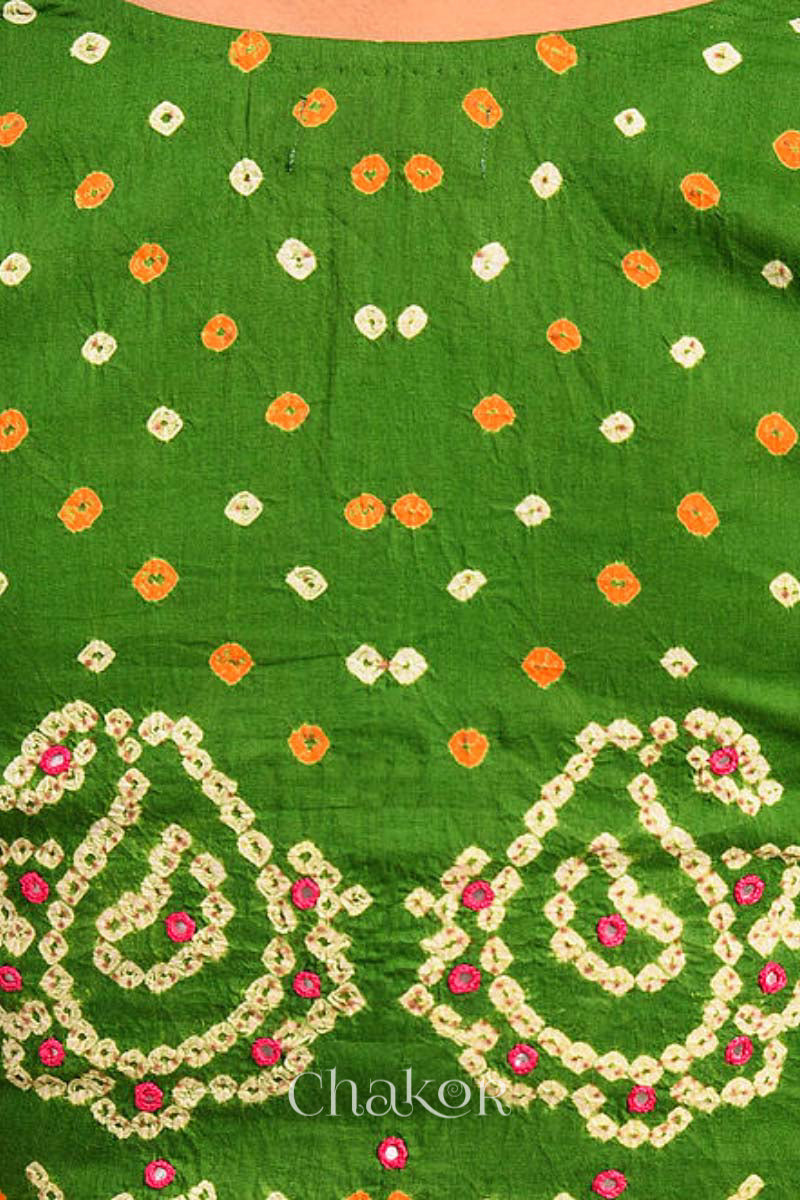 A woman wearing a traditional Mehendi Green Bandhani Cotton Blouse with intricate mirror embroidered Keri - Paisley motifs and boria fabric buttons.