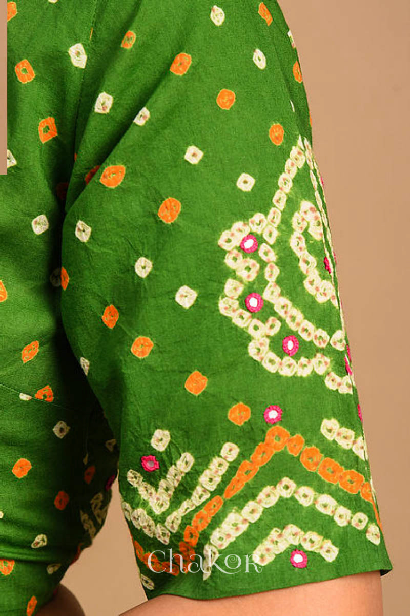A woman wearing a traditional Mehendi Green Bandhani Cotton Blouse with intricate mirror embroidered Keri - Paisley motifs and boria fabric buttons.