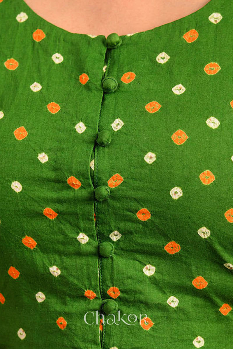A woman wearing a traditional Mehendi Green Bandhani Cotton Blouse with intricate mirror embroidered Keri - Paisley motifs and boria fabric buttons.