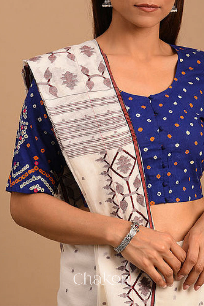 A woman wearing a traditional Navy Blue Bandhani Cotton Blouse with intricate mirror embroidered Keri - Paisley motifs and boria fabric buttons.