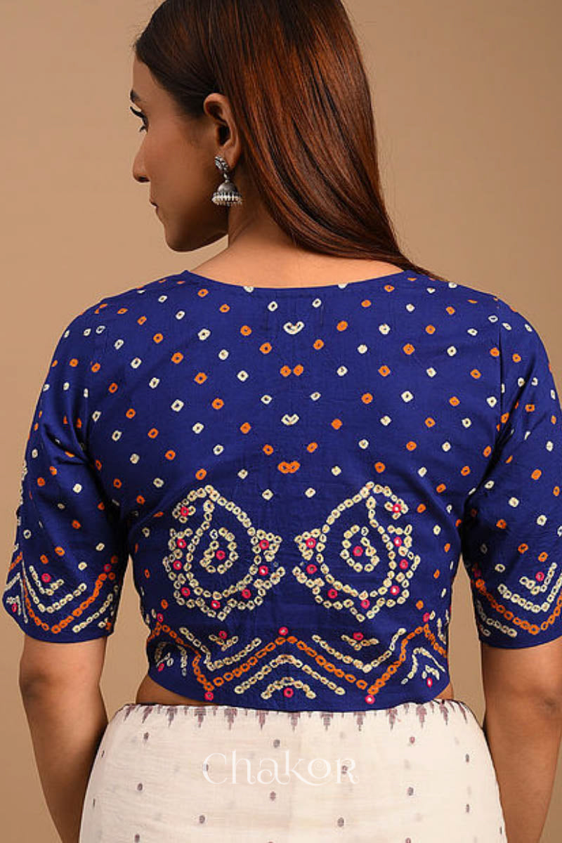 A woman wearing a traditional Navy Blue Bandhani Cotton Blouse with intricate mirror embroidered Keri - Paisley motifs and boria fabric buttons.