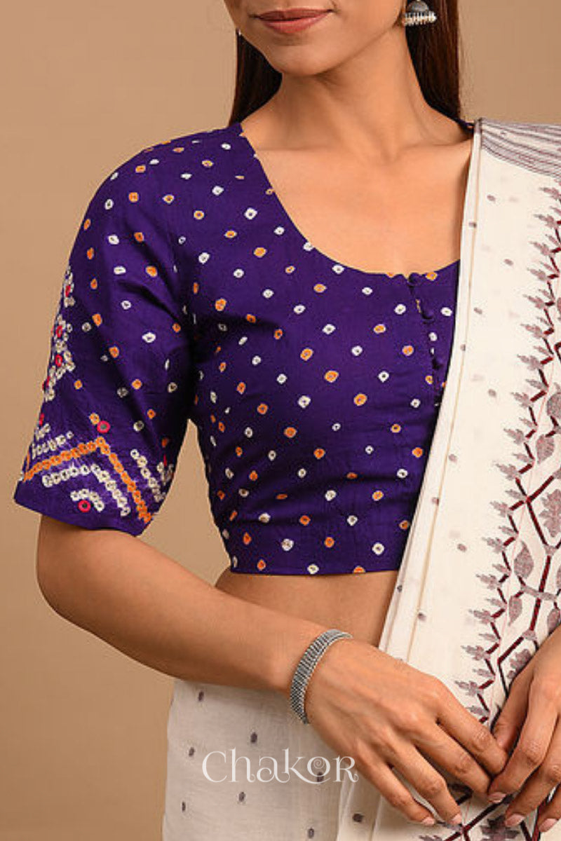 A woman wearing a traditional Purple Bandhani Cotton Blouse with intricate mirror embroidered Keri - Paisley motifs and boria fabric buttons.