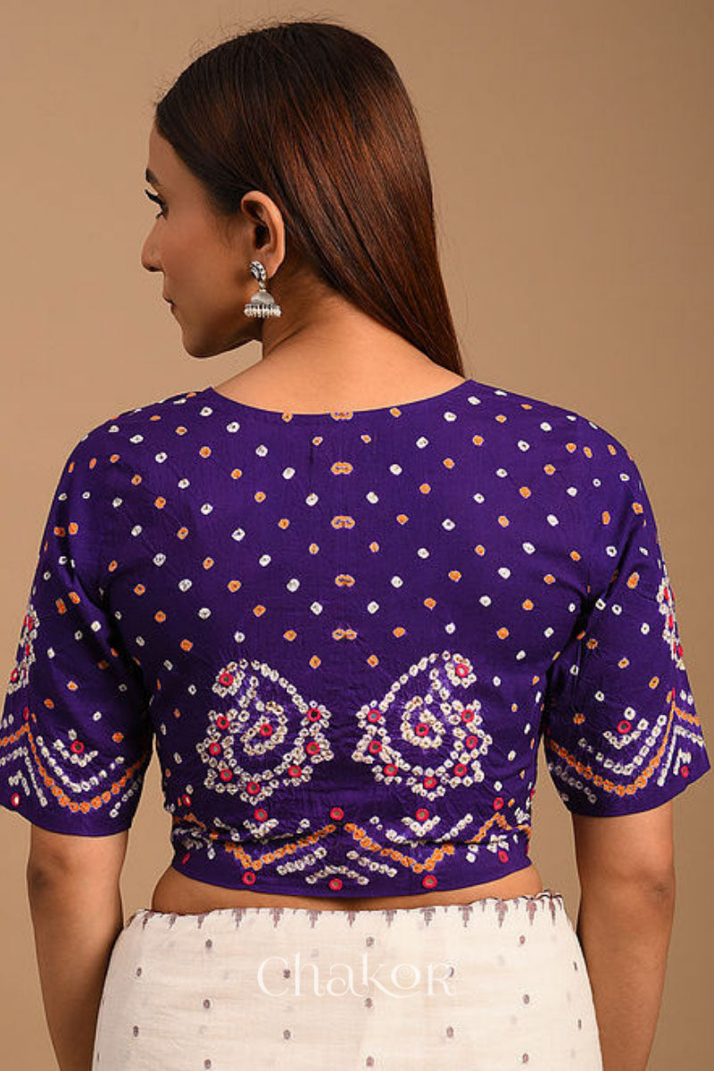 A woman wearing a traditional Purple Bandhani Cotton Blouse with intricate mirror embroidered Keri - Paisley motifs and boria fabric buttons.