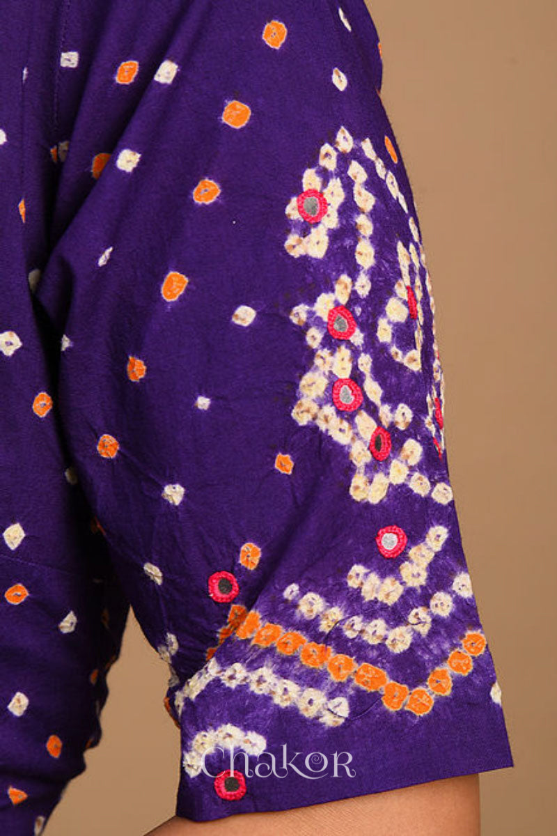 A woman wearing a traditional Purple Bandhani Cotton Blouse with intricate mirror embroidered Keri - Paisley motifs and boria fabric buttons.