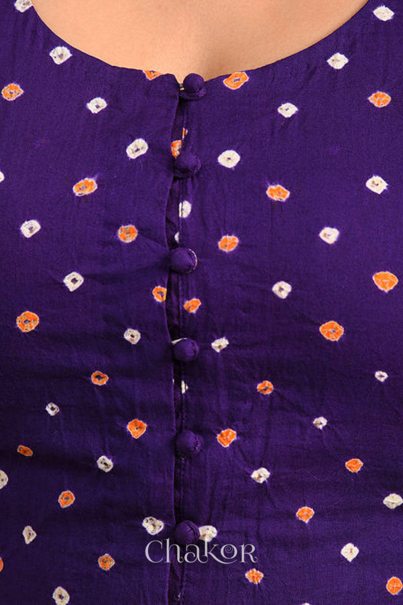 A woman wearing a traditional Purple Bandhani Cotton Blouse with intricate mirror embroidered Keri - Paisley motifs and boria fabric buttons.