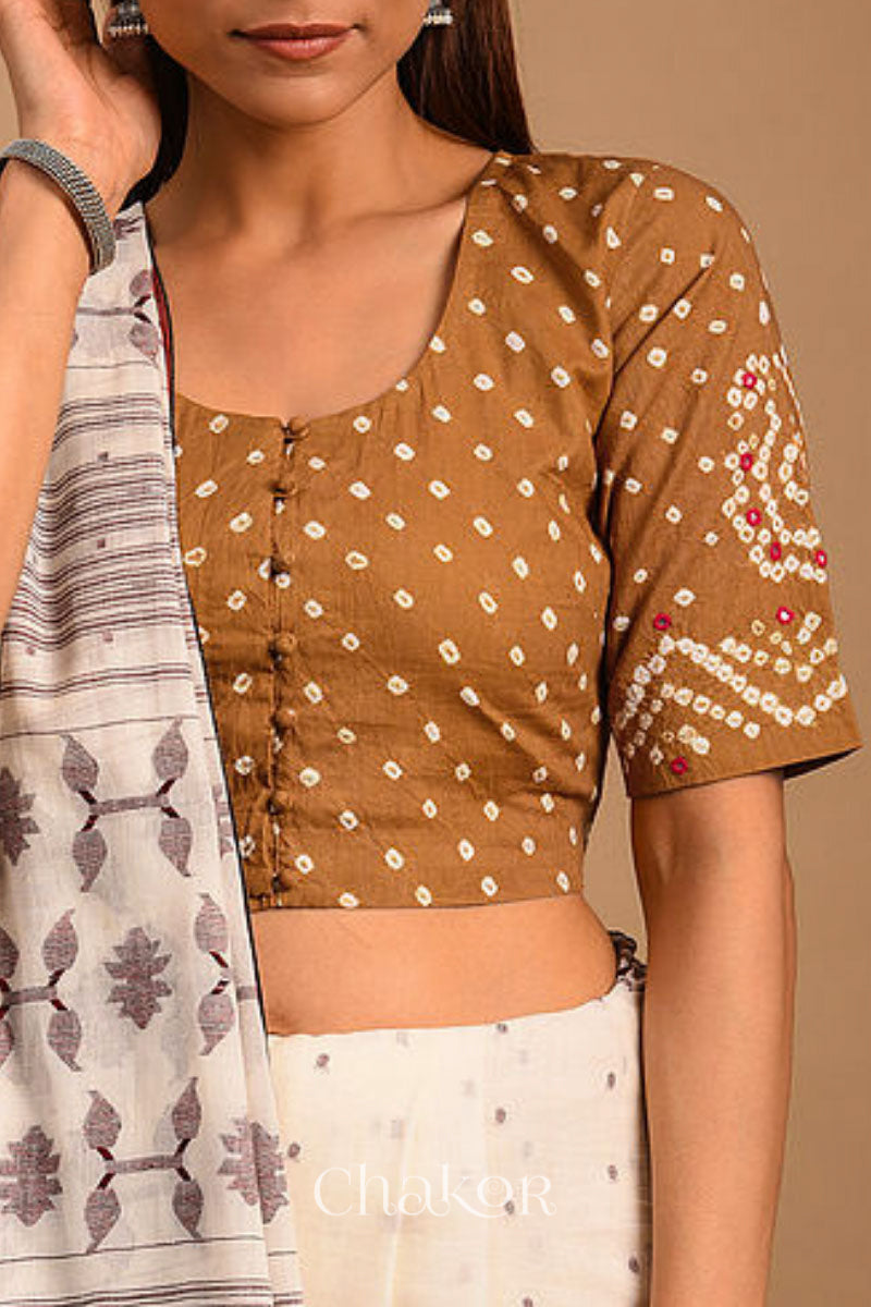 A woman wearing a traditional Mustard Yellow Bandhani Cotton Blouse with intricate mirror embroidered Keri - Paisley motifs and boria fabric buttons.